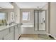 Bright bathroom with double vanity, tub, and separate glass-enclosed shower, offering a luxurious and practical space at 113 Southernwood Dr, Ladson, SC 29456