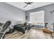 A gray bedroom features wood-look floors, a ceiling fan, and a window letting in natural light at 113 Southernwood Dr, Ladson, SC 29456