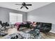 Bedroom with dark sofa and unmade bed features a ceiling fan, rug and light-colored hardwood flooring at 113 Southernwood Dr, Ladson, SC 29456