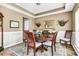 Traditional dining room features a round wood table, decorative wainscoting, and elegant decor for Gathering gatherings at 113 Southernwood Dr, Ladson, SC 29456