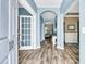 Inviting entryway with light blue walls, hardwood floors, and decorative archways leading into the home's living spaces at 113 Southernwood Dr, Ladson, SC 29456