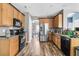 Well-lit kitchen with wood cabinets, modern stainless steel appliances, and granite countertops at 113 Southernwood Dr, Ladson, SC 29456