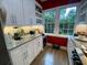 Well-lit kitchen with white cabinets, granite countertops, and a view of the outdoors through a bright window at 116 W 5Th South St # D, Summerville, SC 29483