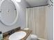 Clean bathroom with granite countertops, round mirror, and a shower with white curtain at 117 Canaberry Cir, Summerville, SC 29483