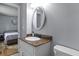 Cozy bathroom with oval mirror, granite countertop, and an adjacent bedroom at 117 Canaberry Cir, Summerville, SC 29483