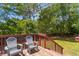 Cozy backyard deck with chairs overlooking the backyard with lush greenery and a wood fence at 117 Canaberry Cir, Summerville, SC 29483