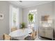 Bright dining area features a white table, seating for four, a modern cabinet, and a door to the outside at 1225 Blakeway St # 407, Charleston, SC 29492