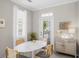 Bright dining area features a white table, seating for four, a modern cabinet, and a door to the outside at 1225 Blakeway St # 407, Charleston, SC 29492
