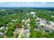 An aerial view showcases the home nestled among lush green trees in a quiet neighborhood under a bright blue sky at 1416 Glencoe Dr, Mount Pleasant, SC 29464