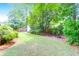 The sprawling backyard showcases a fire pit, lush lawn, mature trees and landscaping at 1416 Glencoe Dr, Mount Pleasant, SC 29464