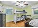 Bright bedroom featuring a bunk bed, wood floors, ceiling fan and white-trimmed window at 1416 Glencoe Dr, Mount Pleasant, SC 29464