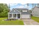 Charming blue home featuring a well-manicured lawn and a cozy front porch with rocking chairs at 148 Haverhill St, Summerville, SC 29486