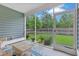 View from the screened-in porch showing the cozy seating area and the view of the green backyard, creating an inviting space at 148 Haverhill St, Summerville, SC 29486