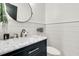 Modern powder room featuring marble countertop, sleek black vanity, round mirror, and shiplap walls at 1517 Faith St, Mount Pleasant, SC 29466