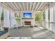 Comfortable covered porch with fireplace, TV, and ample seating with natural light at 1517 Faith St, Mount Pleasant, SC 29466