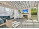 Inviting covered porch with a fireplace, TV, comfortable seating, and sheer curtains for privacy at 1517 Faith St, Mount Pleasant, SC 29466