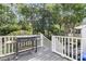 Outdoor deck area featuring a gas grill, white railing, and wooded backyard views at 1517 Faith St, Mount Pleasant, SC 29466