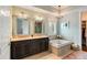 Bright bathroom with double sink vanity, soaking tub, and decorative lighting at 1527 Wando View St, Charleston, SC 29492