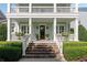 Beautiful home exterior showcasing a covered porch with entry stairs and manicured shrubs at 1527 Wando View St, Charleston, SC 29492