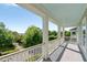 Covered porch with stately columns and view of mature trees and lake in the distance at 1527 Wando View St, Charleston, SC 29492