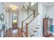 Elegant foyer featuring hardwood floors, a staircase with white risers, and a decorative chandelier, creating a welcoming entrance at 1545 Calaveras Cir, Mount Pleasant, SC 29466