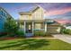 Charming two-story home featuring a welcoming front porch, well-manicured lawn, and attached garage, perfect for a Gathering at 1545 Calaveras Cir, Mount Pleasant, SC 29466