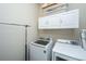 Functional laundry room featuring a washer and dryer with upper cabinet storage and a clothes rack at 1545 Calaveras Cir, Mount Pleasant, SC 29466