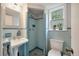Charming blue-tiled bathroom featuring a pedestal sink and a walk-in shower with a window at 1603 Culpepper Cir, Charleston, SC 29407