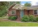 Charming brick home with a blue door and decorative shutters surrounded by lush greenery, enhancing its curb appeal at 1603 Culpepper Cir, Charleston, SC 29407