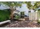 Outdoor dining area with brick patio, white fence, and mature trees offering shade at 166 1/2 Queen St, Charleston, SC 29401