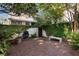 Private brick patio with lush greenery, water feature, and seating, providing a tranquil outdoor escape at 166 1/2 Queen St, Charleston, SC 29401