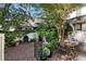 Serene brick patio featuring a dining area, grill, and mature trees, offering a peaceful outdoor setting at 166 1/2 Queen St, Charleston, SC 29401