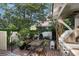 Charming brick patio with a dining set, grill, and lush greenery, creating a private outdoor retreat at 166 1/2 Queen St, Charleston, SC 29401