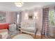 Charming pink Bedroom with a white crib, pink accents, and patterned curtains at 166 1/2 Queen St, Charleston, SC 29401