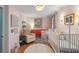 Charming pink Bedroom with a white crib, pink accents, and patterned curtains at 166 1/2 Queen St, Charleston, SC 29401