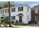 Charming two-story white stucco home with black shutters and a well-manicured front yard at 166 1/2 Queen St, Charleston, SC 29401