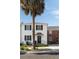 Two-story white stucco home featuring black shutters and a prominent palm tree in the front at 166 1/2 Queen St, Charleston, SC 29401