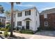 Charming two-story home with a white exterior, black shutters, and a well-manicured front yard at 166 1/2 Queen St, Charleston, SC 29401