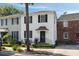 Elegant two-story home with a white facade, black shutters, and a charming front entrance at 166 1/2 Queen St, Charleston, SC 29401