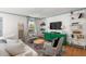Cozy living room with green bureau, white sofa, patterned rug, and hardwood floors at 166 1/2 Queen St, Charleston, SC 29401