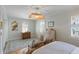 Bright main bedroom featuring hardwood floors, white furniture, and a unique ceiling fan at 166 1/2 Queen St, Charleston, SC 29401