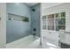 Bathroom featuring a bathtub with blue tiling and a recessed niche, with a view of outside from the window at 169 Southwold Cir, Goose Creek, SC 29445