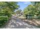 Long private driveway framed by lush greenery, leading to a beautiful home with a welcoming front porch at 1761 Old Military Rd, Charleston, SC 29412