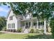 Elegant home with a spacious porch, detailed railings, and a well-maintained lawn and landscaping at 1761 Old Military Rd, Charleston, SC 29412