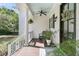 Cozy front porch with a ceiling fan, dark trimmed windows, a bench, and decorative plants at 1761 Old Military Rd, Charleston, SC 29412