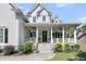 Inviting front porch with stylish columns, ceiling fans, and lush landscaping, perfect for relaxing outdoors at 1761 Old Military Rd, Charleston, SC 29412