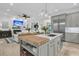 Modern kitchen features an island with barstool seating that opens to the living room with a fireplace and TV at 1761 Old Military Rd, Charleston, SC 29412