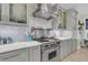 Gourmet kitchen featuring stainless steel appliances, custom cabinets, a decorative backsplash, and marble countertops at 1761 Old Military Rd, Charleston, SC 29412