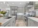 Modern kitchen boasts stainless steel appliances, a large island, and custom gray cabinets for storage at 1761 Old Military Rd, Charleston, SC 29412