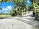 Charming home featuring a light yellow exterior, green trees, and a spacious gravel area at 1915 Quitman St, North Charleston, SC 29405
